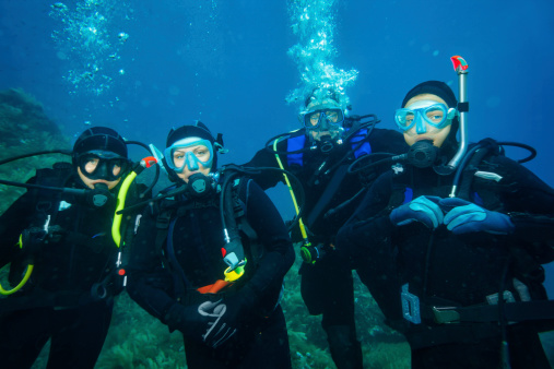 Scuba diving. Underwater scene with diver group in blue.