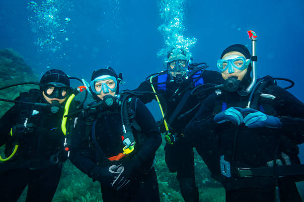 Scuba Diver Scuba diving. Underwater scene with diver group in blue. deep sea diving underwater underwater diving scuba diving stock pictures, royalty-free photos & images