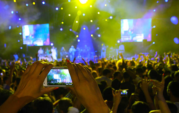 Girl filming with smartphone Girl filming with smartphone open air concert, blurred stage. Shallow dof rocker nails stock pictures, royalty-free photos & images