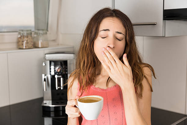 sonnolento donna bere il caffè nel mattino - yawning women drink coffee cup foto e immagini stock