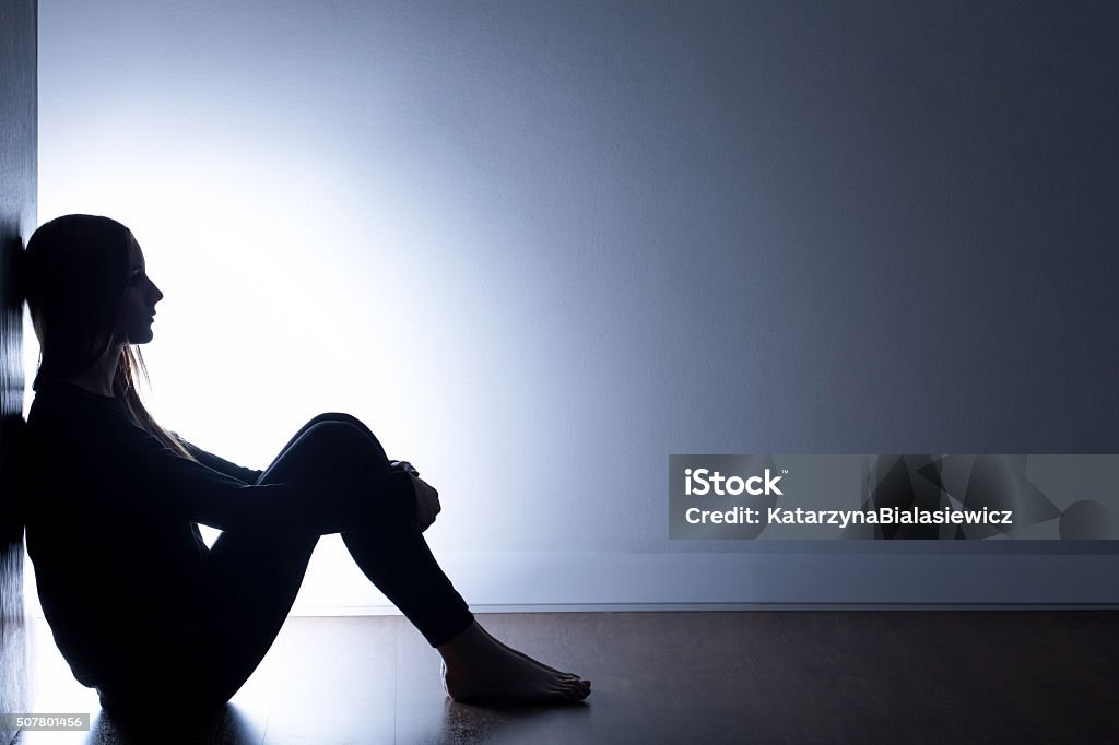 My life is such a mess Teenager with depression sitting alone in dark room Depression - Sadness Stock Photo