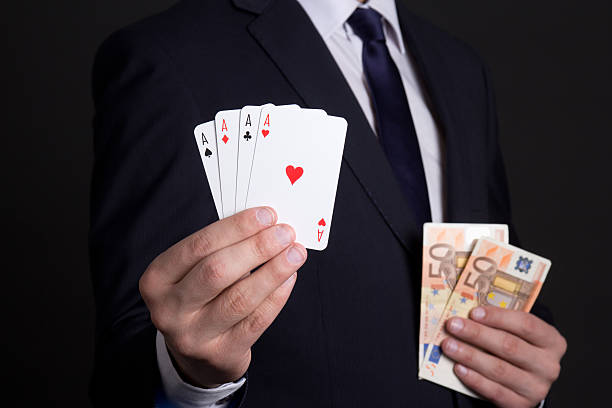 istock four aces cards and money in mans hands 507803142