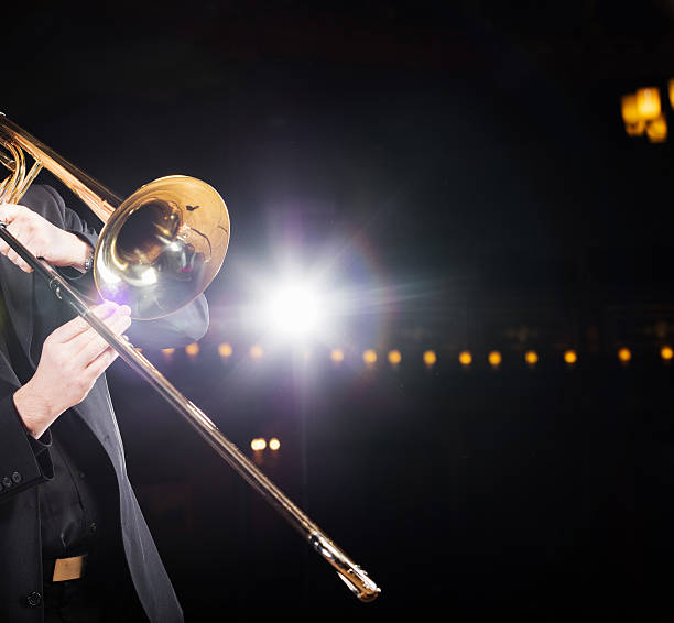 Trombone player with backlight Trombone player with backlight and trombone. big band jazz stock pictures, royalty-free photos & images