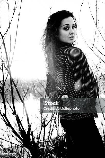 Portrait Of Elegant Woman Standing On Beach Against Trees Stock Photo - Download Image Now