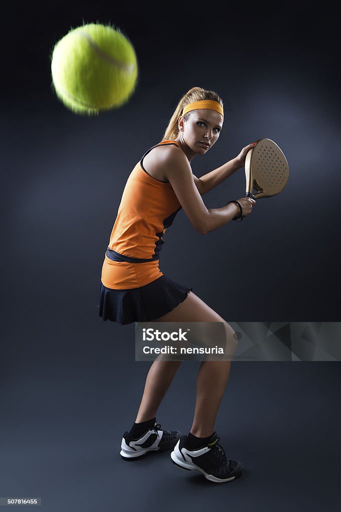 Beautiful woman playing padel indoor. Isolated on black. Portrait of beautiful woman playing padel indoor. Isolated on black. Padel Stock Photo