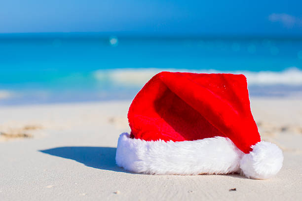 istock Close up Santa hat on a white sandy beach 507816589