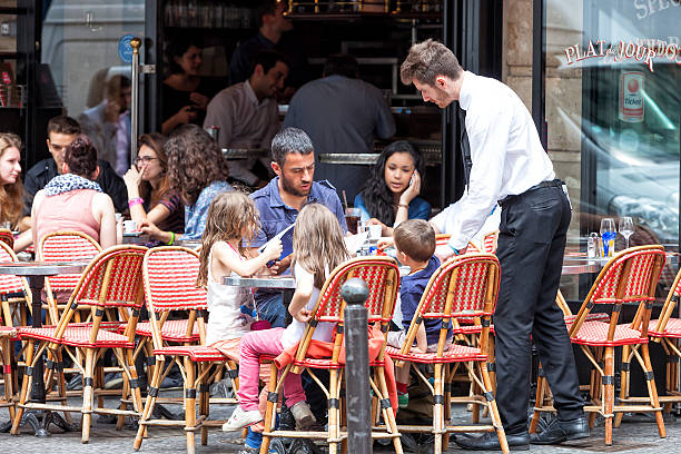 Paris, France - July 15, 2014: Waiter serving drinks in street cafe of Boulevard Saint-Germain.
