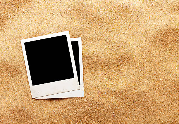 istock Old style empty photo cards lying on a sea sand 507819431