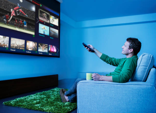 Man watching television in living room  entertainment center stock pictures, royalty-free photos & images