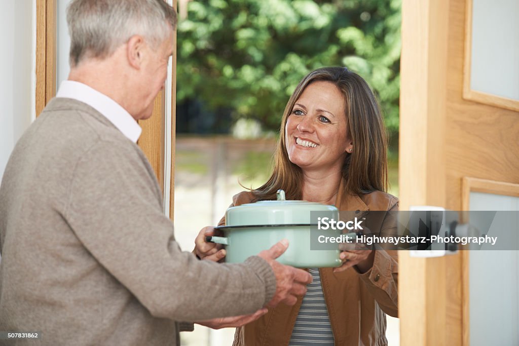 Donna portando pasto per anziani vicino - Foto stock royalty-free di Vicino di casa