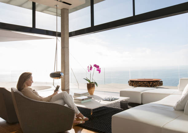istock Woman using cell phone in modern living room 507832073