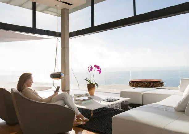 Photo of Woman using cell phone in modern living room