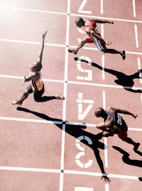 corridori che tagliano il traguardo - atleta di atletica leggera foto e immagini stock