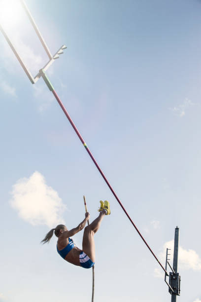 pole jumper acercándose a la barra - salto de altura fotografías e imágenes de stock