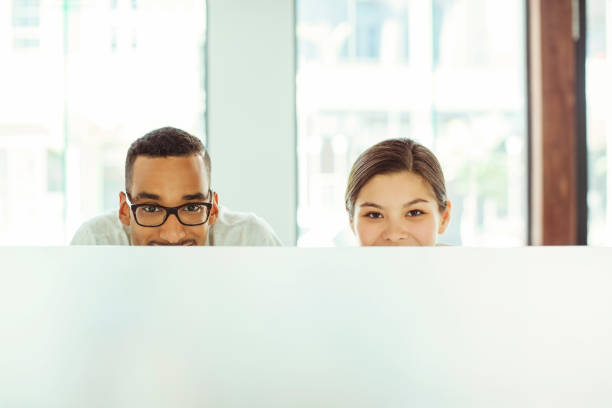istock People peering over cubicle in office 507832403