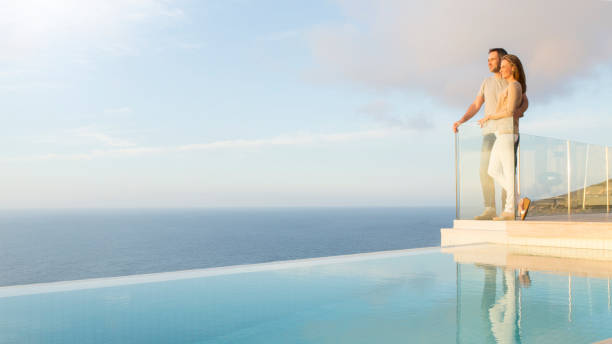paar mit blick auf den ozean vom modernen balkon - vacations luxury balcony heterosexual couple stock-fotos und bilder