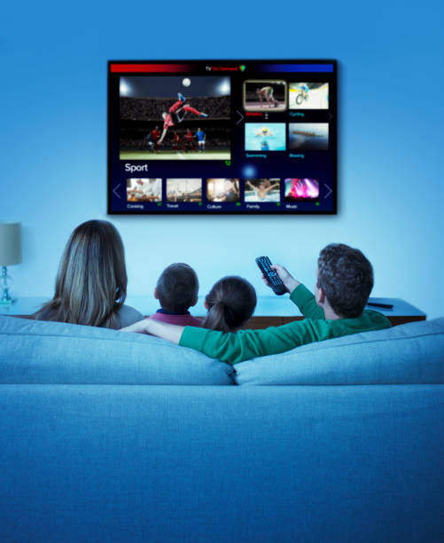 family watching television in living room - watch imagens e fotografias de stock