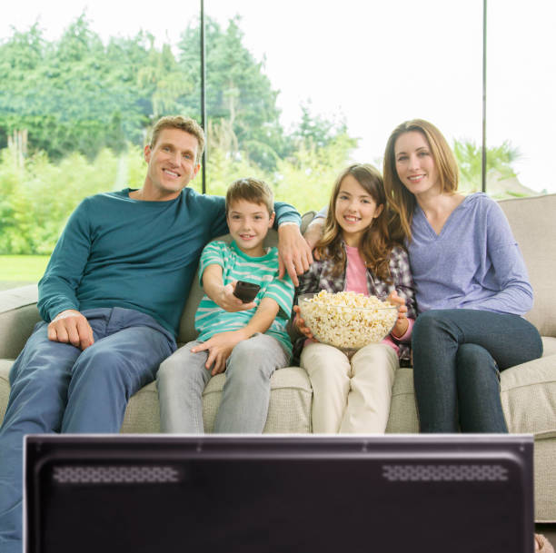 família assistindo televisão na sala de estar - entertainment center watching tv television popcorn - fotografias e filmes do acervo