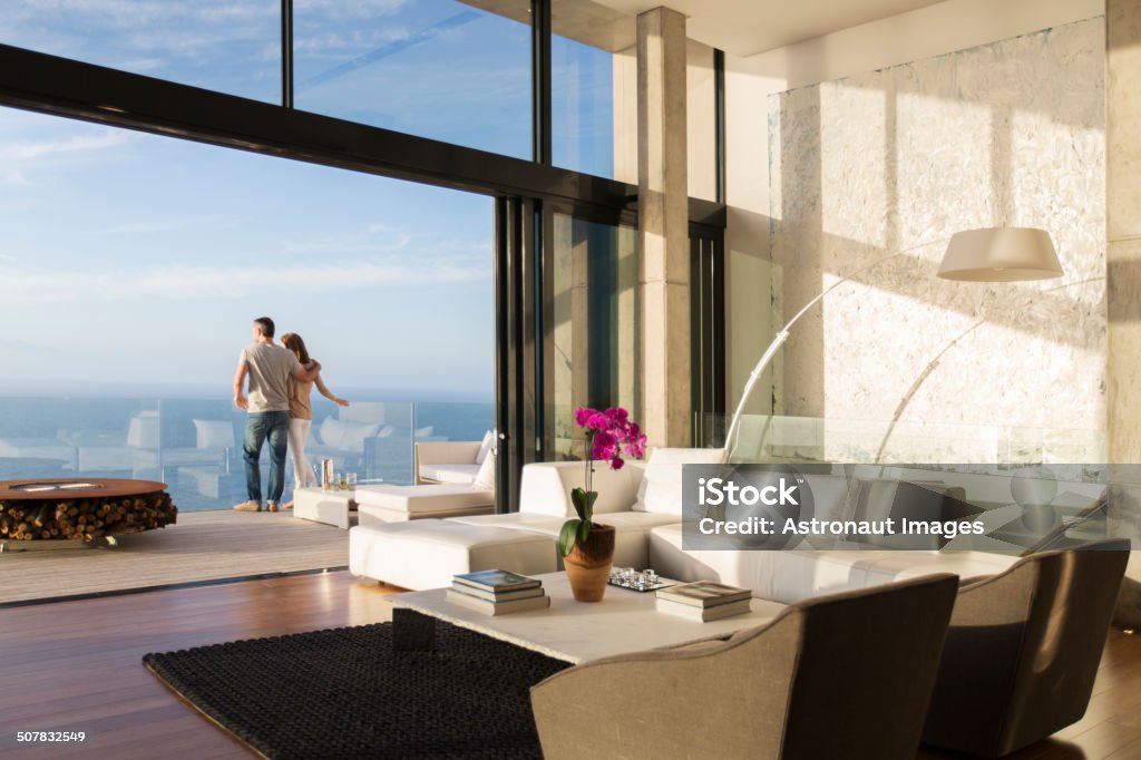 Couple standing on balcony of modern house  Luxury Stock Photo