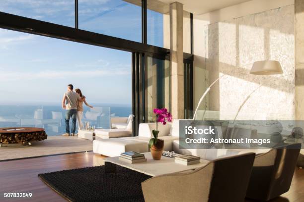 Couple Standing On Balcony Of Modern House Stock Photo - Download Image Now - Luxury, Domestic Life, Home Interior