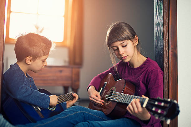 istock Sister and brother practicing playing guitars 507832604
