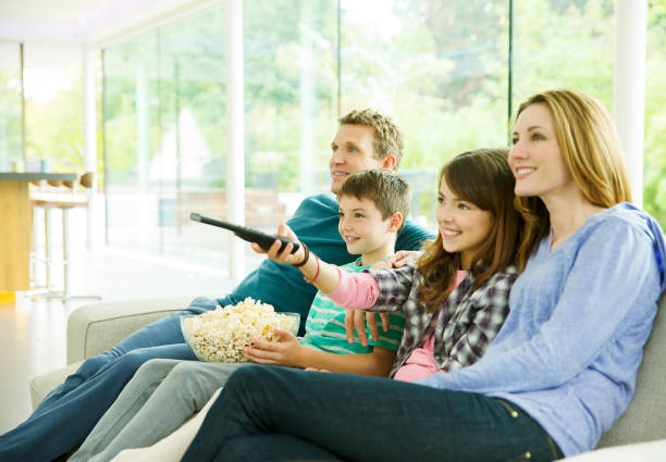 família assistindo televisão na sala de estar - entertainment center watching tv television popcorn - fotografias e filmes do acervo