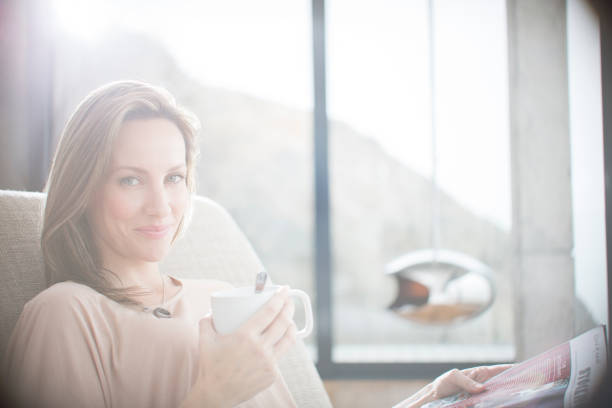 istock Woman having cup of coffee on sofa 507832989