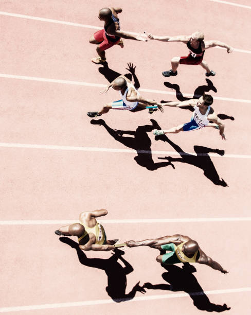 istock Relay runners handing off batons on track 507833157