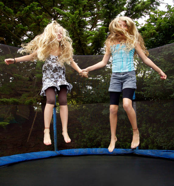 Two girl playing at trampoline
