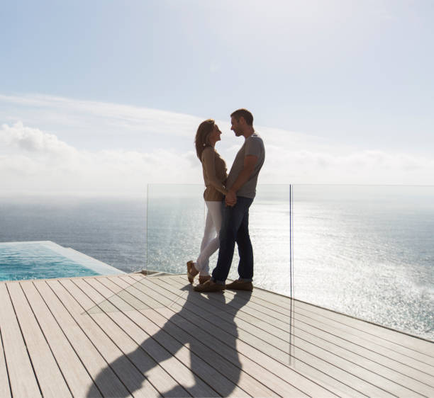 paar auf modernem balkon mit meerblick - vacations luxury balcony heterosexual couple stock-fotos und bilder