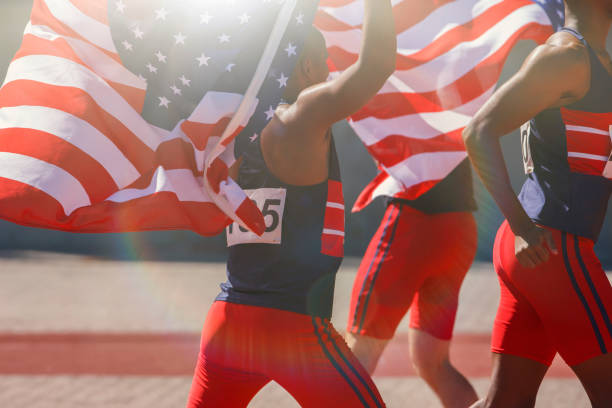 istock Track and field athletes holding American flags on track 507833409