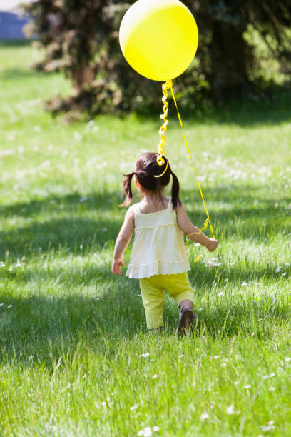 istock Girl carrying balloon in backyard 507833453
