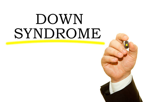 Human hand writing Down Syndrome on a transparent wipe board