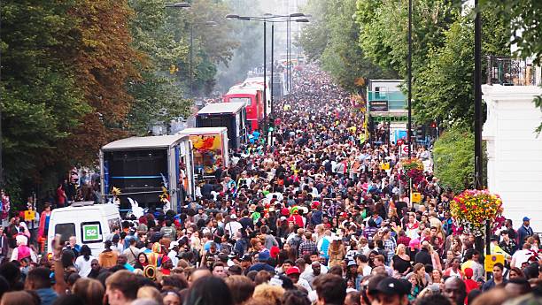 Notting Hill Carnival crowd London, UK - August 10, 2014: Crowds gather to dance, eat, and celebrate the Notting Hill Carnival. notting hill stock pictures, royalty-free photos & images