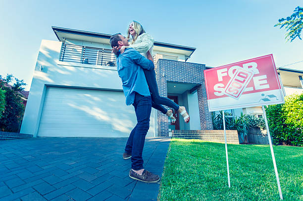 Couple standing in front of a new home.