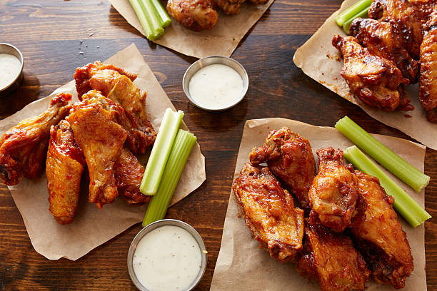 different flavored chicken wings on wooden table