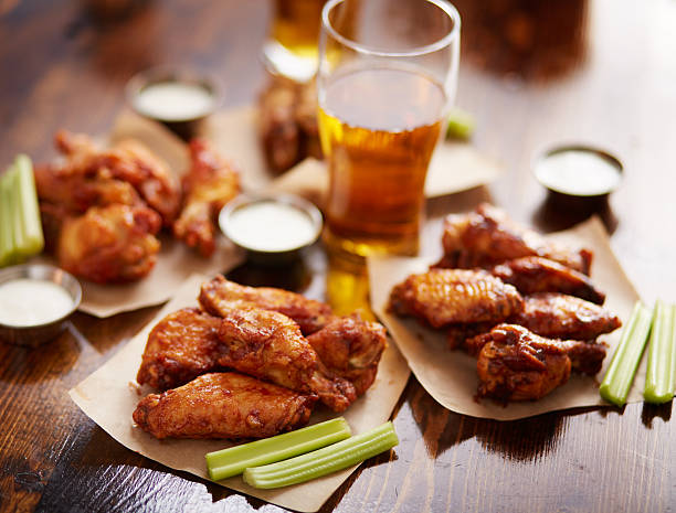 istock different flavored chicken wings on wax paper served with beer, 507845286
