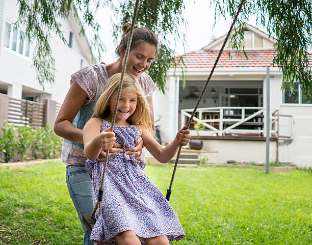 istock Mother pushing daughter on a swing 507848234