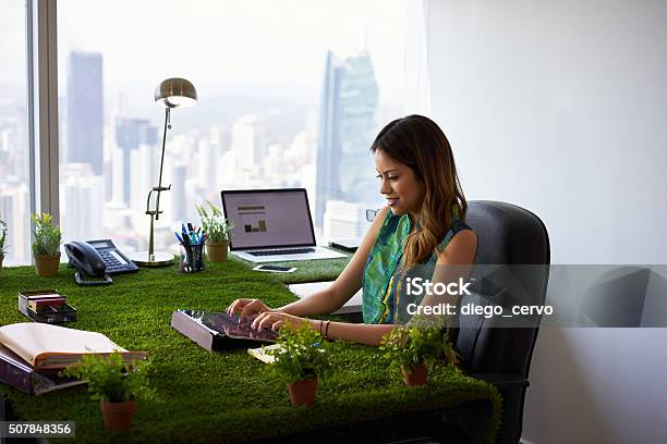 Environmentalist Woman Types Email With Tablet On Office Desk Stock Photo - Download Image Now