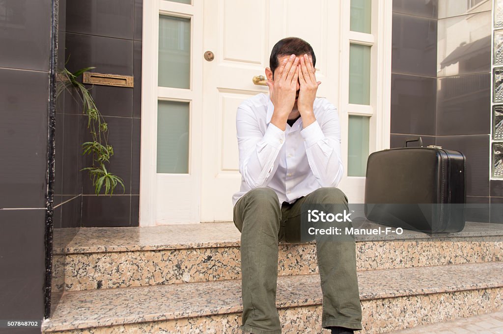 just divorced portrait of man crying at the doorway with a suitcase as concept of divorced man Exclusion Stock Photo