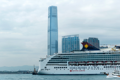 Hong Kong, China - May 3rd, 2014: Superstar Virgo Cruise Ship at the Ocean Terminal on the Kowloon Peninsula, beautiful ICC Tower in the backgrounds.