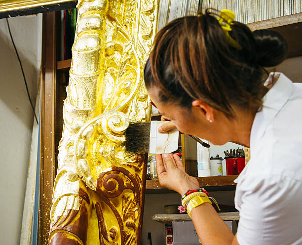 Application of gold leaf to an antique picture frame stock photo