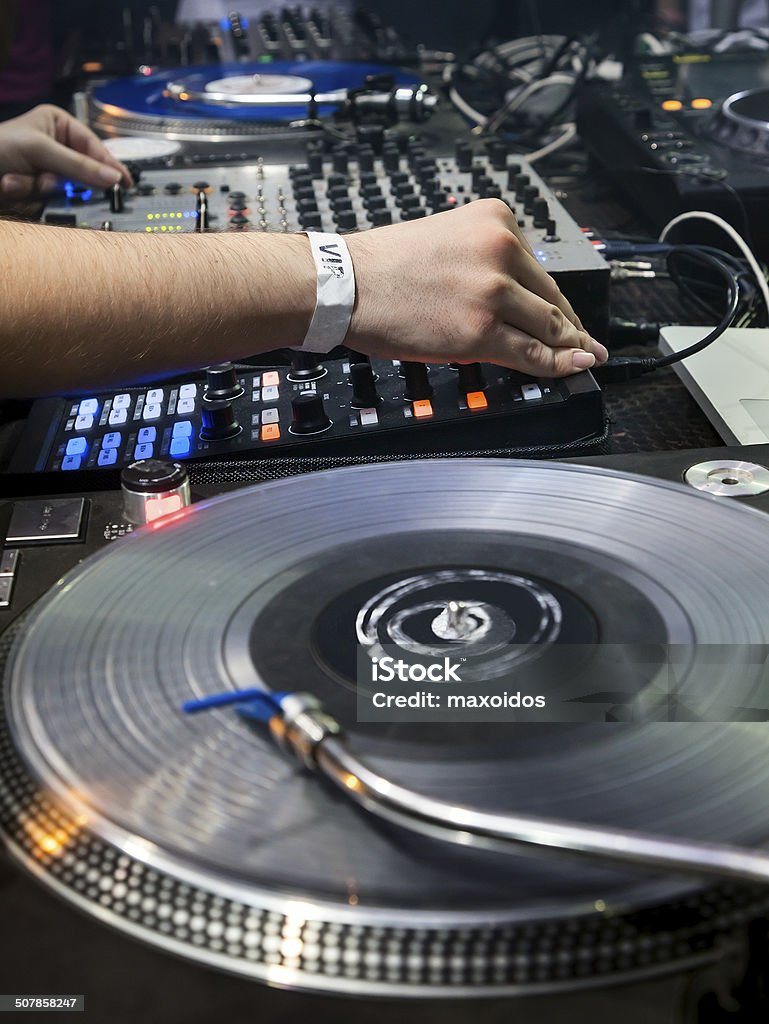 DJ plays set in vinyl player Dj mixes the track in the nightclub at party. Vinyl Player in foreground Arts Culture and Entertainment Stock Photo