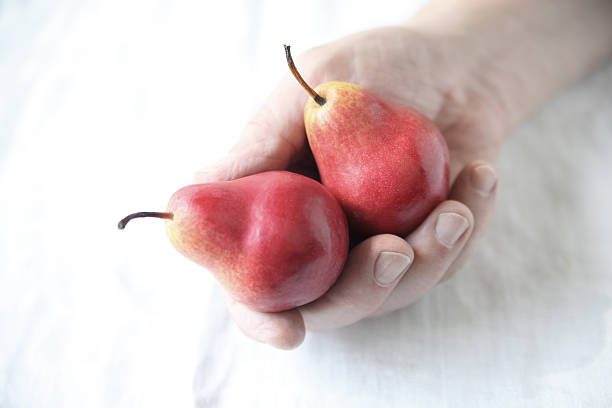 istock Man holds red Forelle pears 507860057