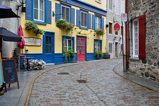 Colourful building along a curved stone street in Quebec French historic old town after a rainfall.