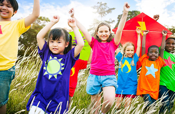 istock Kids Diverse Playing Kite Field Young Concept 507869086