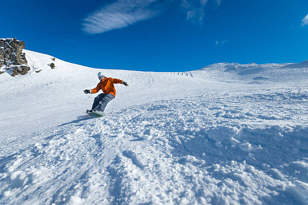 snowboarder tornitura sul cielo blu al giorno - skiing sports helmet powder snow ski goggles foto e immagini stock