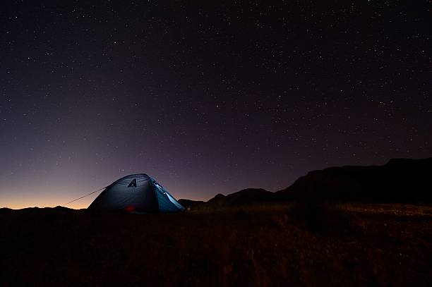 A camper's tent silhouetted against a starry Milky Way in the Northern Cape, South Africa, on the Namib border.