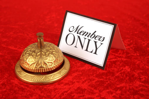 Members Only on sign next to ornate gold service bell on a red velvet background