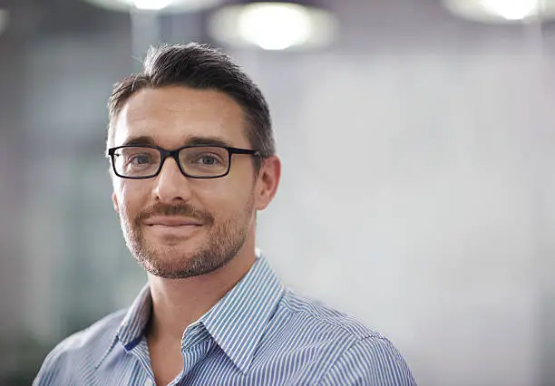 A cropped portrait of a handsome businessman standing in an office